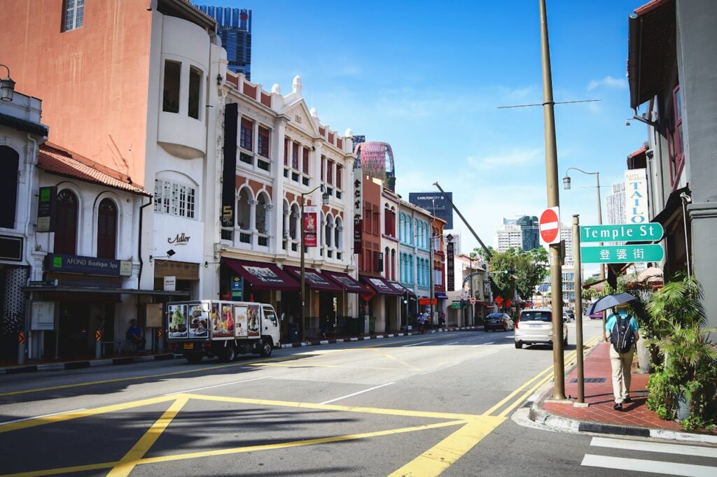 Bustling street view in Singapore's Chinatown featuring colorful buildings and Temple Street sign.